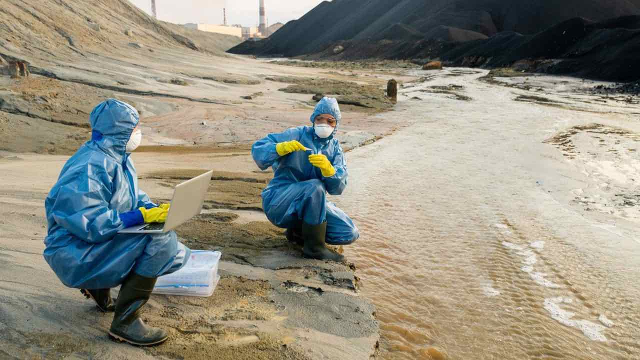 Scienziati vicino al fiume pieno di pesticidi